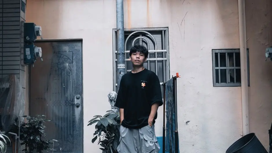 Tiga pria muda memakai kaos oversized, celana cargo, dan sneakers di trotoar kota